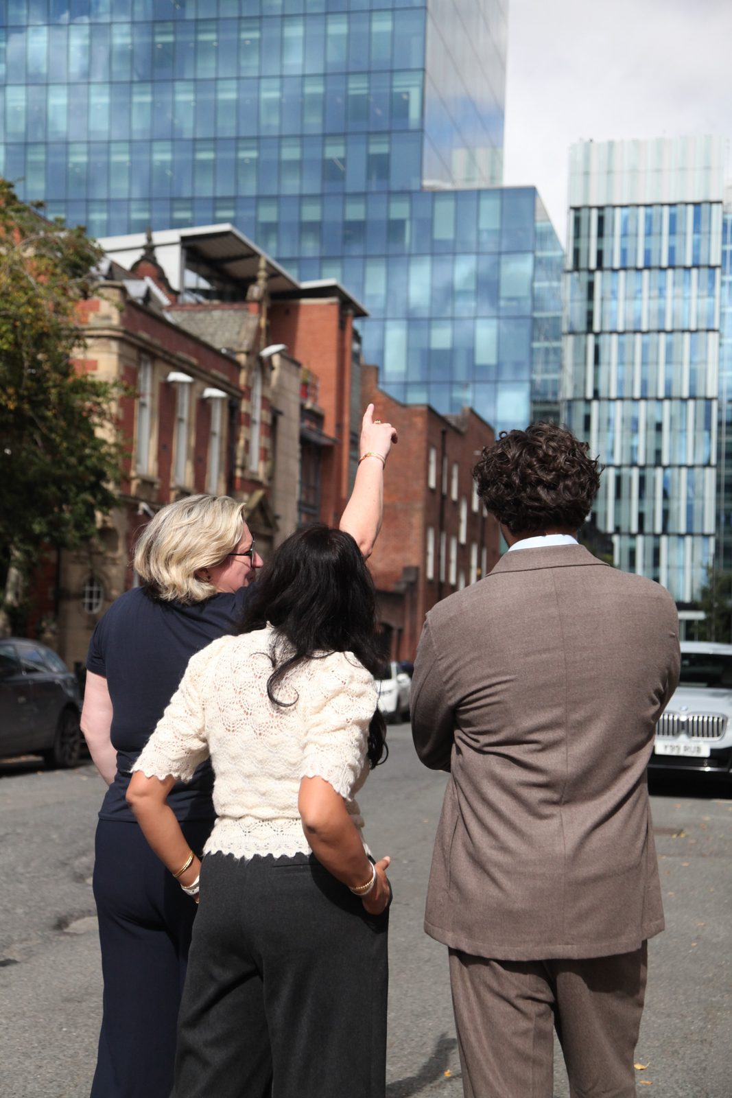 The three partners looking up at towers in Manchester